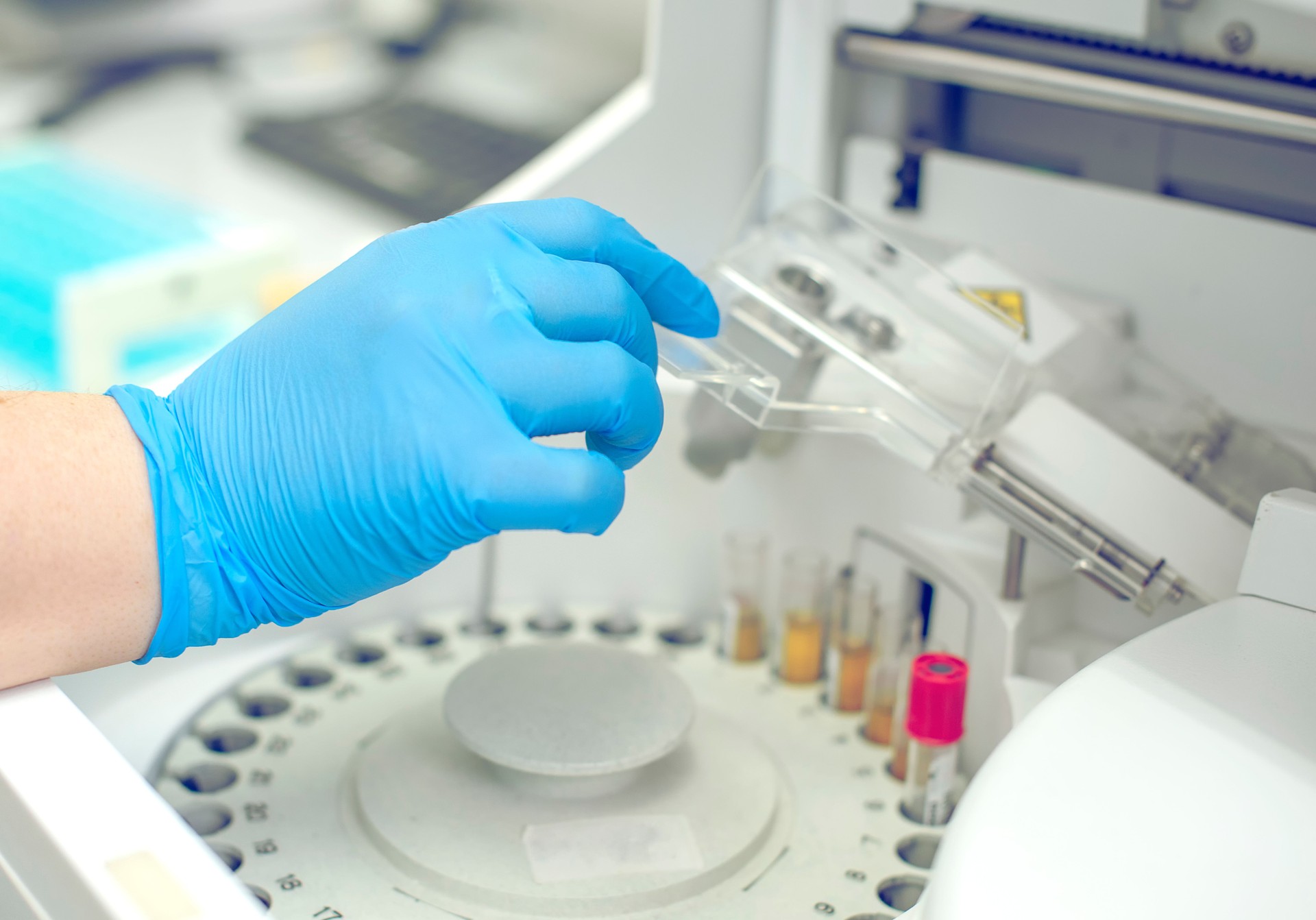 Woman working in a laboratory on a modern machine for blood testing. Doctor checks the blood of the patients. Blood research in a modern scientific workplace