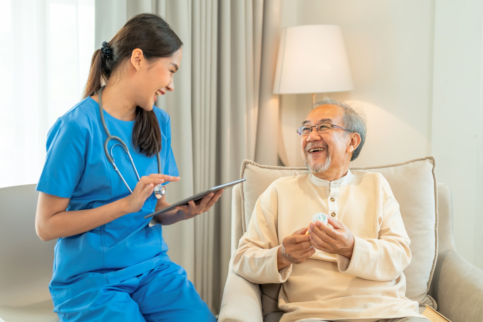 Female home caregiver explain about result lav test with senior man, sitting in living room and explain to him carefully. Senior adult had satisfied about  lab test result.